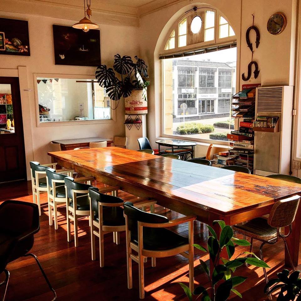 The big communal table under the arched window